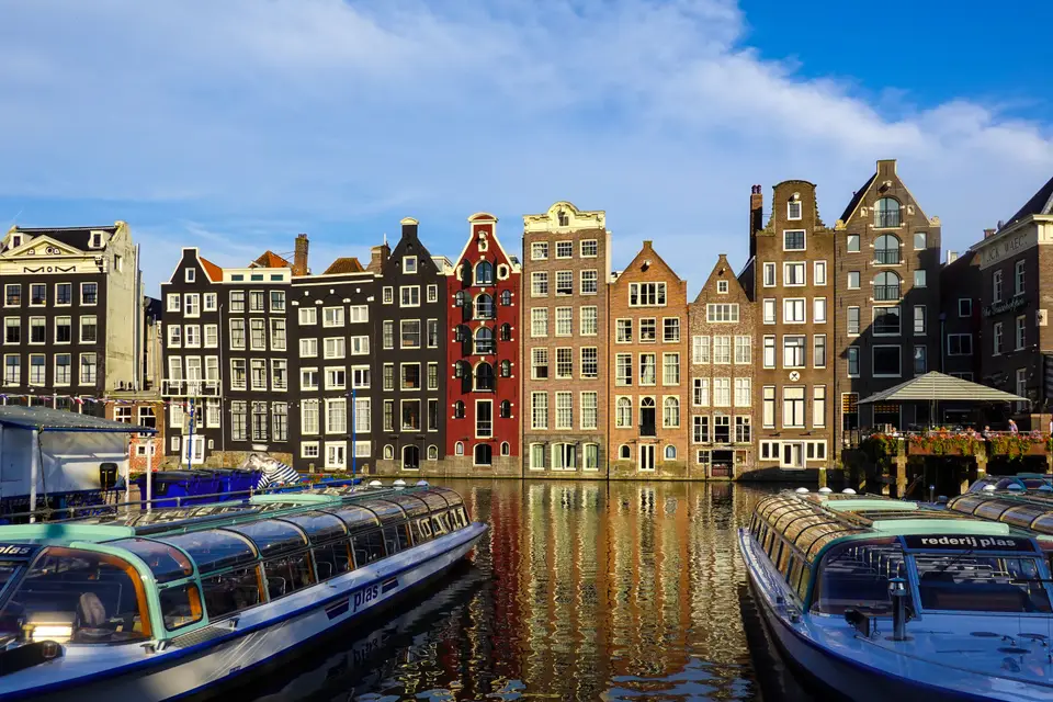 Colourful historic houses and boats along an Amsterdam canal