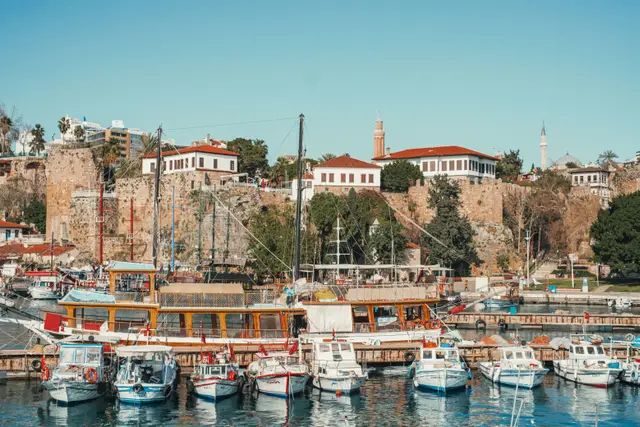 Boats in the Kaleiçi harbour, with the walls and the Fluted Minaret behind