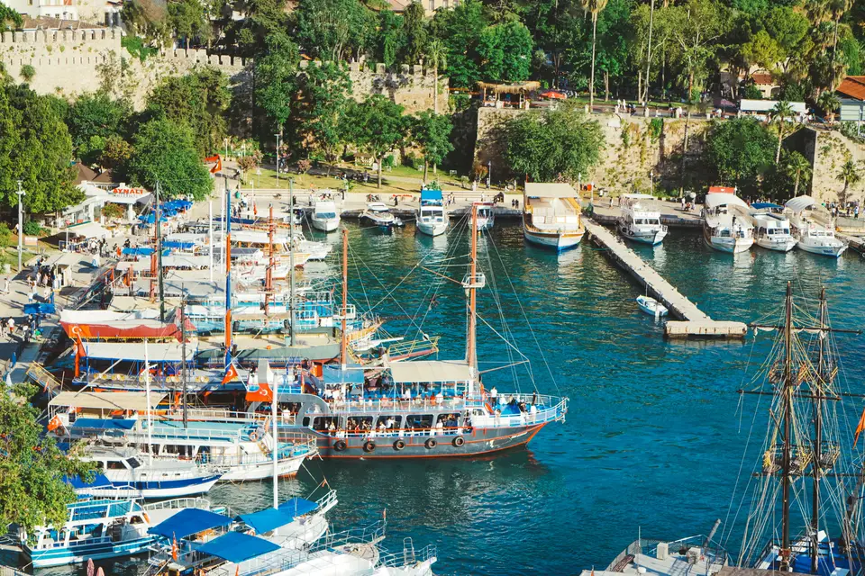 Kaleiçi old harbour with moored boats beneath green slopes